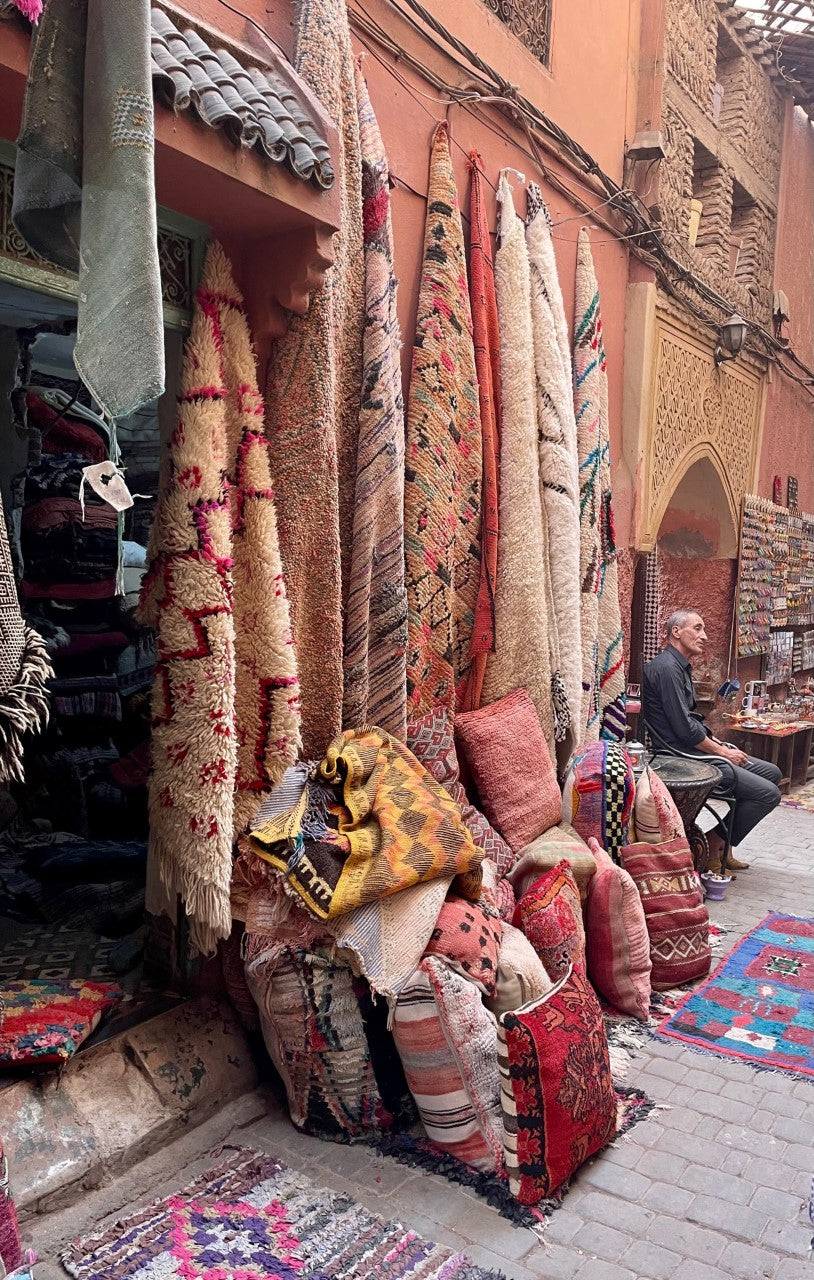 Shopping i Marrakech med farverige tæpper og håndlavede møbler i lokale butikker.